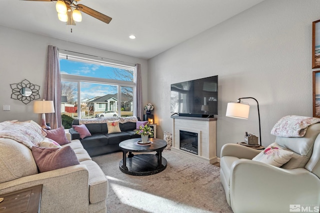 living area with a glass covered fireplace, ceiling fan, and recessed lighting