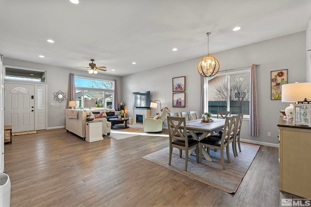 dining area with recessed lighting, baseboards, wood finished floors, and a glass covered fireplace