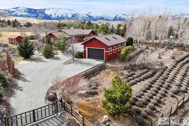 view of front of property featuring a mountain view, a garage, fence, driveway, and stucco siding