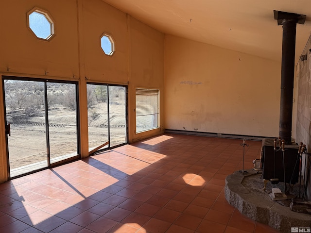 unfurnished sunroom featuring a wood stove and vaulted ceiling