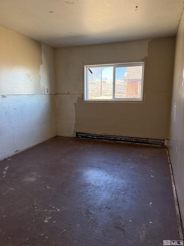 unfurnished room featuring baseboard heating and concrete flooring