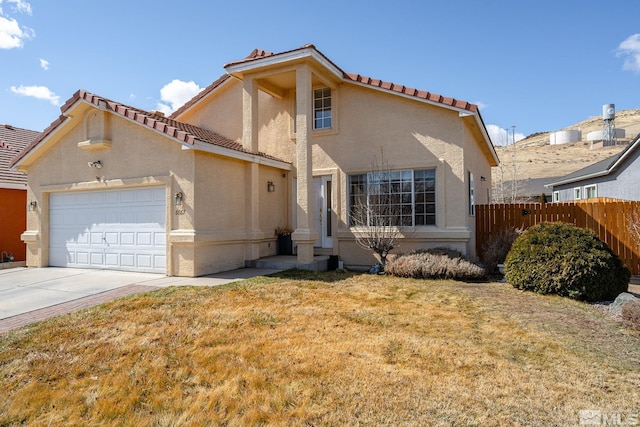 mediterranean / spanish home with stucco siding, driveway, fence, a front yard, and a garage