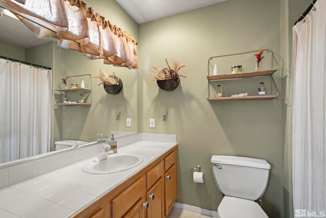 bathroom with vanity, toilet, and baseboards