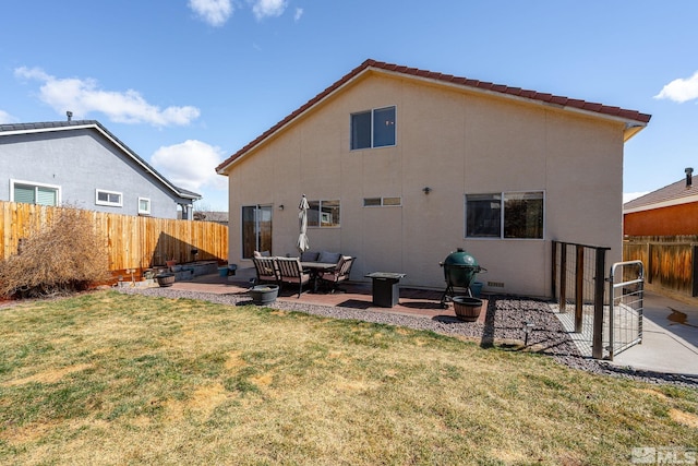 rear view of house with stucco siding, a lawn, fence private yard, and a patio area