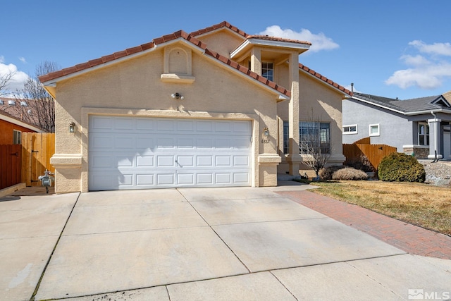 mediterranean / spanish-style house featuring stucco siding, concrete driveway, a garage, and fence