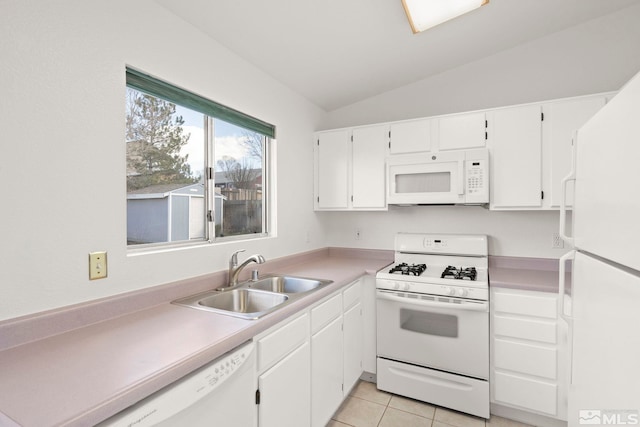 kitchen featuring a sink, white cabinetry, white appliances, light tile patterned floors, and vaulted ceiling