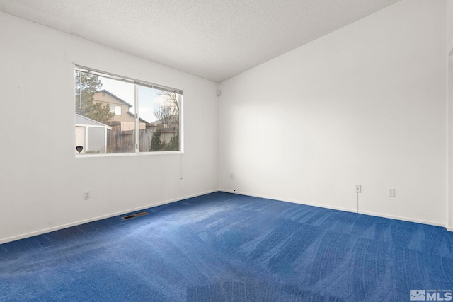 spare room with baseboards, carpet, visible vents, and a textured ceiling