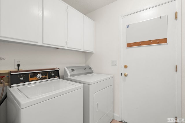 clothes washing area with washer and dryer and cabinet space