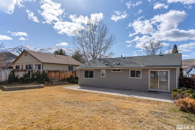 back of house featuring a patio area, a lawn, a mountain view, and fence