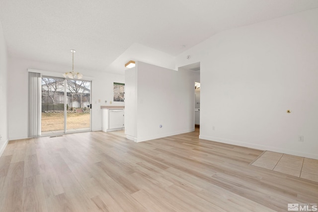 unfurnished living room featuring visible vents, baseboards, an inviting chandelier, light wood-style flooring, and vaulted ceiling