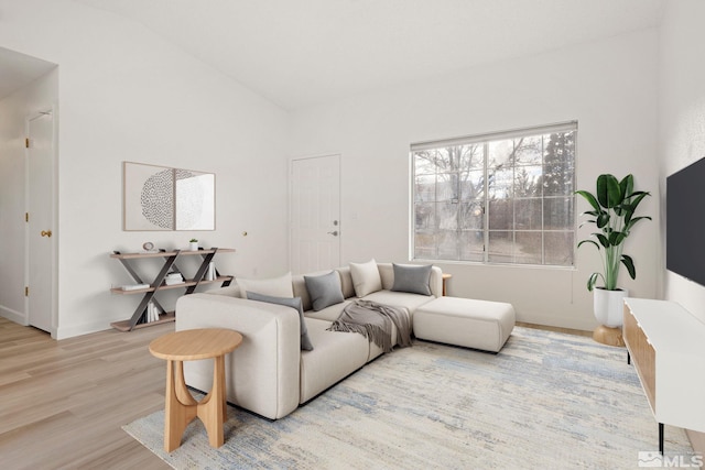 living area with vaulted ceiling and wood finished floors