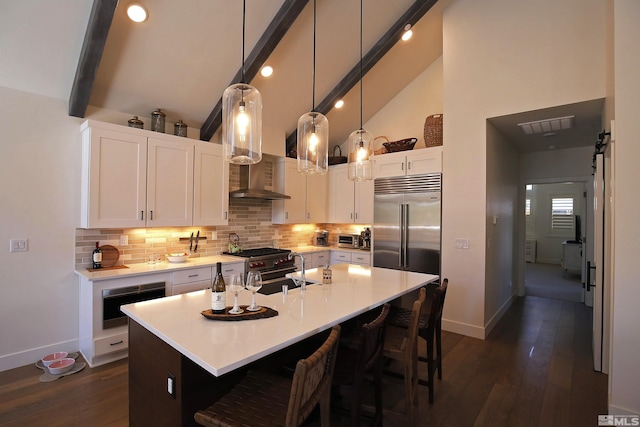 kitchen with tasteful backsplash, visible vents, high quality appliances, a breakfast bar, and light countertops