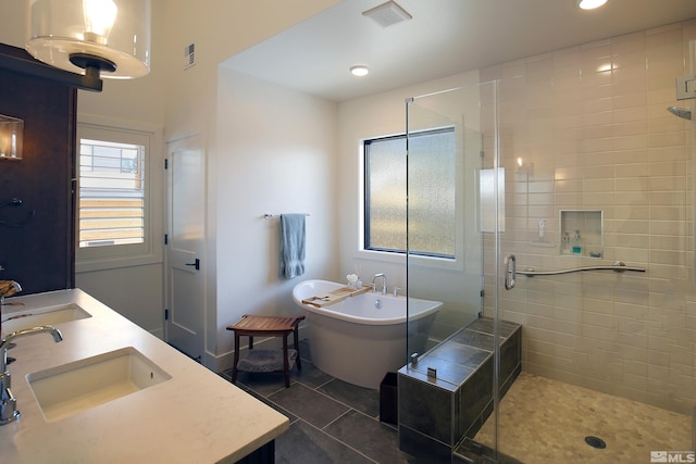 full bathroom with a freestanding bath, a sink, visible vents, and a shower stall