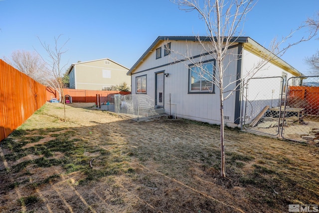 back of property featuring a fenced backyard and a yard