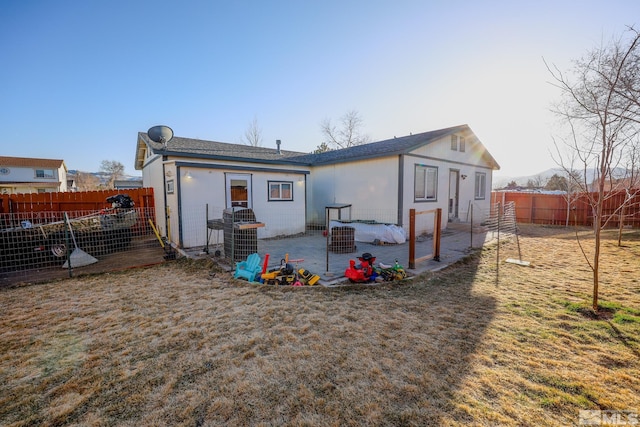 back of property with a fenced backyard and a patio