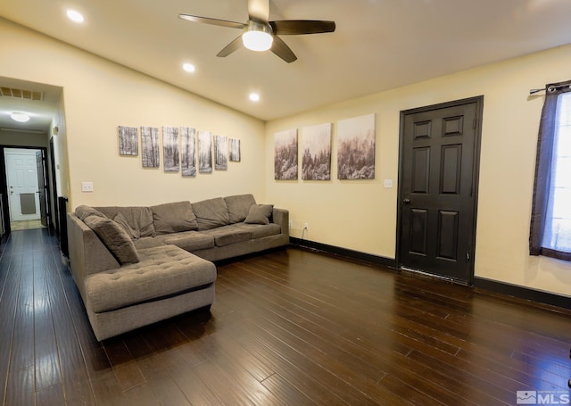 living area with dark wood-style floors, vaulted ceiling, visible vents, and a ceiling fan