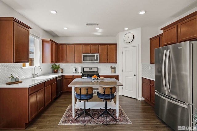 kitchen with stainless steel appliances, dark wood-style flooring, a sink, and light countertops