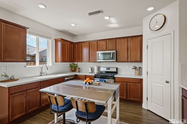 kitchen with visible vents, appliances with stainless steel finishes, dark wood-style flooring, and a sink