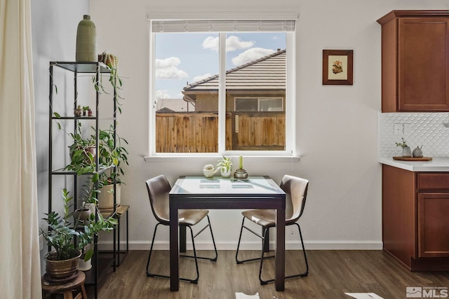 dining space with dark wood-style flooring and baseboards