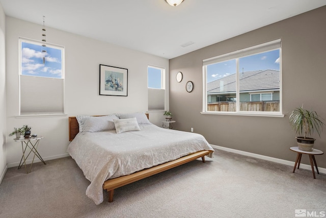 carpeted bedroom with multiple windows and baseboards