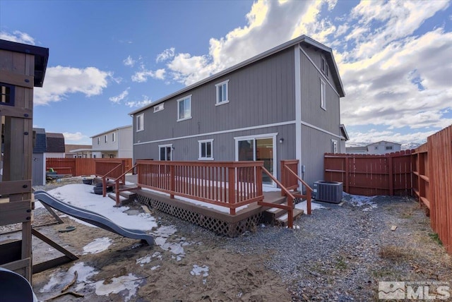 rear view of house featuring a deck, central AC unit, and a fenced backyard