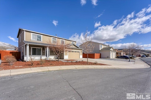 traditional home with a garage, concrete driveway, and fence