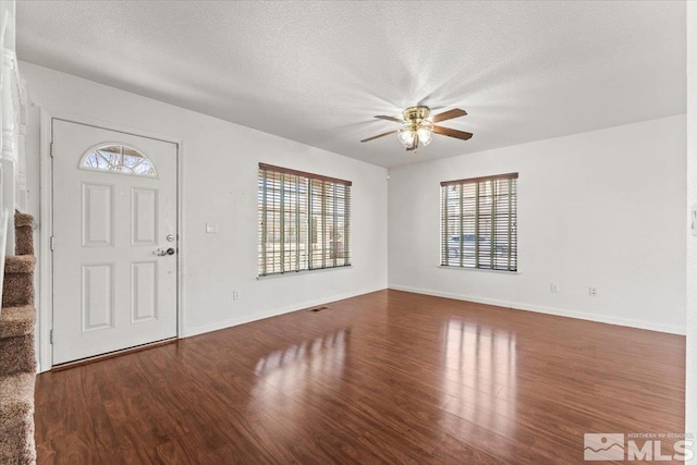 entrance foyer featuring plenty of natural light, stairs, and wood finished floors