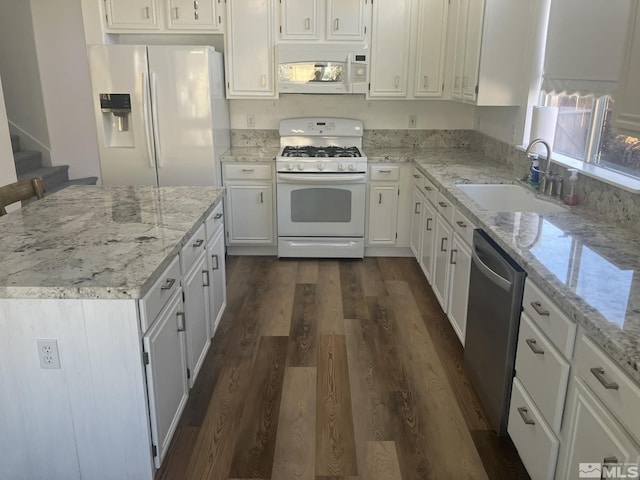 kitchen with white appliances, dark wood-style floors, white cabinetry, and a sink