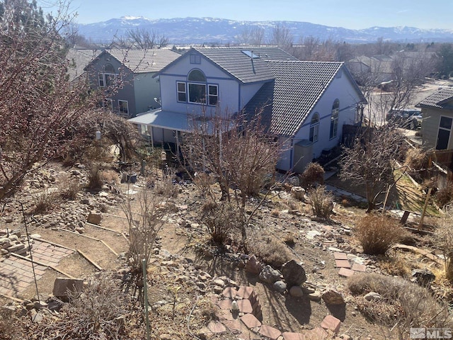 exterior space with a tile roof and a mountain view