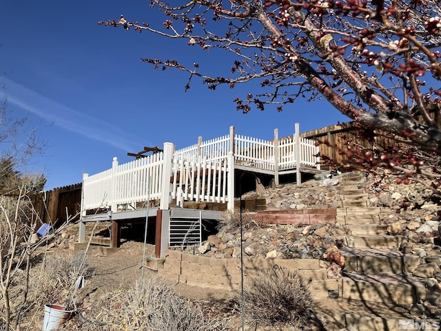 back of house featuring a deck and stairs