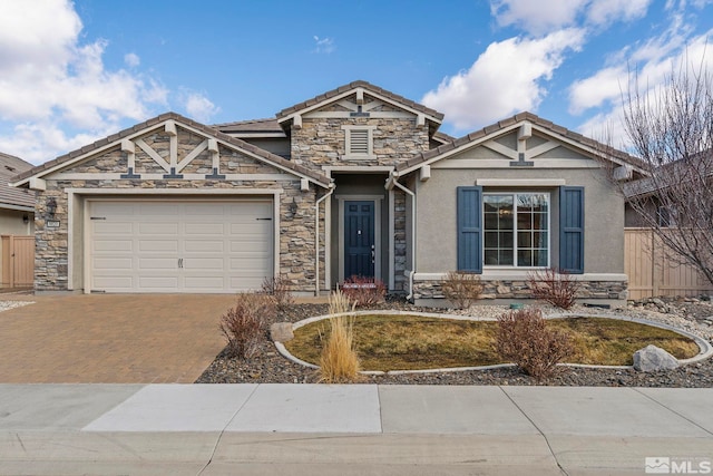 craftsman-style home with a garage, a tiled roof, stone siding, decorative driveway, and stucco siding