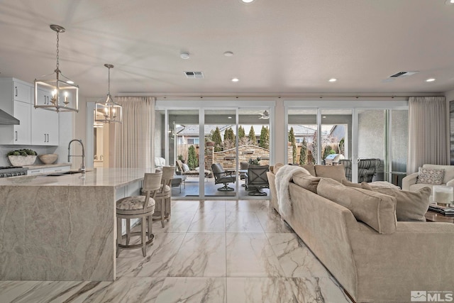 living area featuring plenty of natural light, visible vents, and recessed lighting