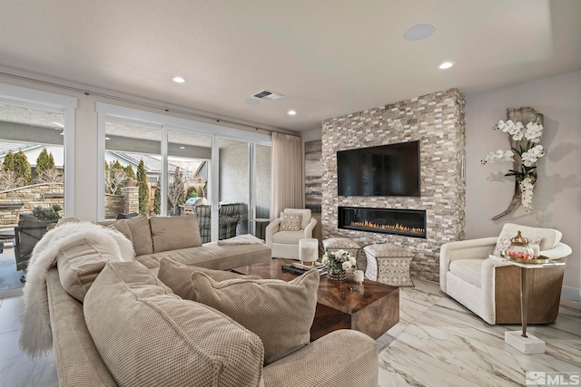 living room featuring a fireplace, visible vents, and recessed lighting