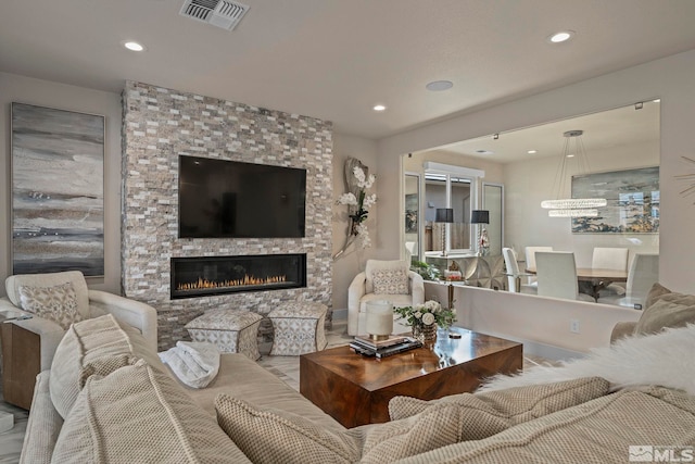 living room with a fireplace, visible vents, and recessed lighting