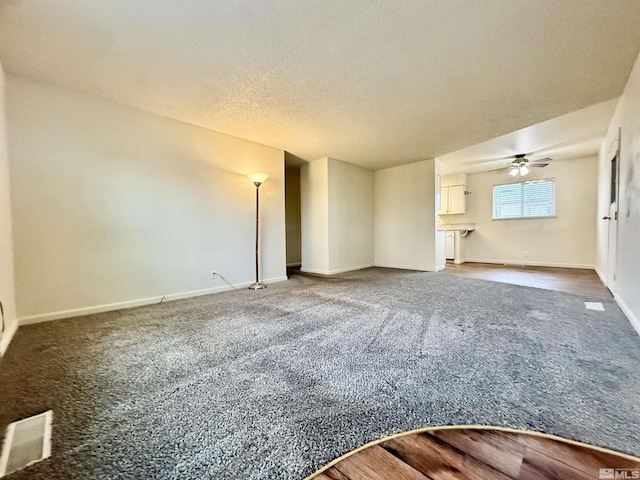 unfurnished living room with baseboards, visible vents, ceiling fan, a textured ceiling, and carpet flooring