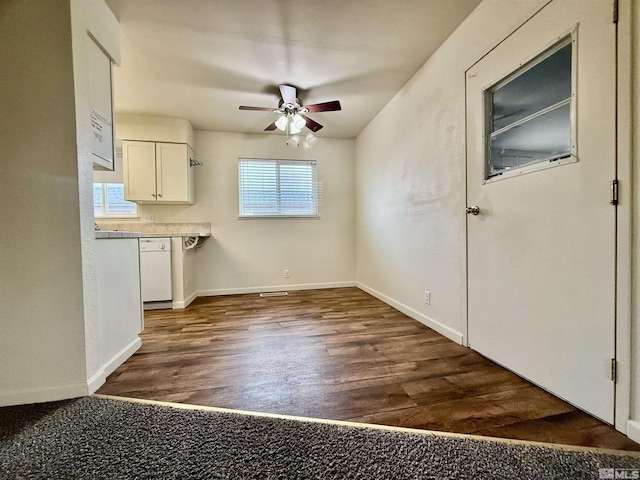 interior space with ceiling fan, baseboards, and dark wood finished floors