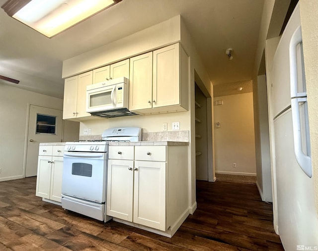 kitchen with white appliances, baseboards, white cabinets, dark wood-type flooring, and light countertops