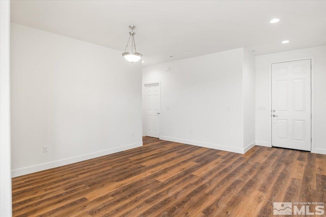 unfurnished room with recessed lighting, wood finished floors, and baseboards