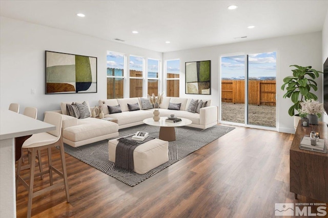 living area with visible vents, wood finished floors, and recessed lighting