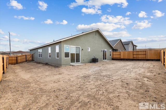 back of property featuring central AC, a fenced backyard, and stucco siding