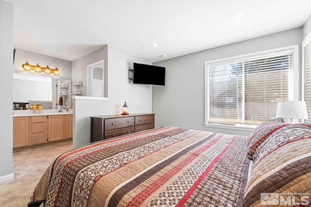 bedroom featuring light carpet, ensuite bath, and recessed lighting