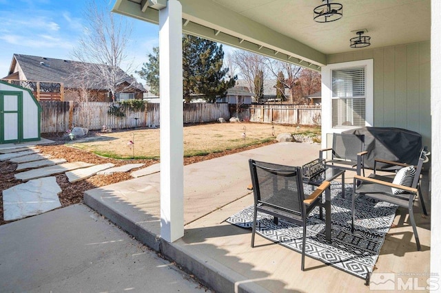 view of patio featuring an outbuilding, a shed, and a fenced backyard