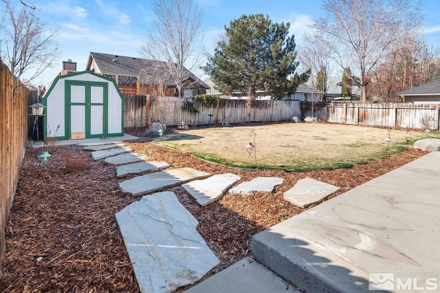 view of yard with an outbuilding, a fenced backyard, and a shed