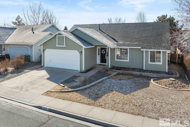 ranch-style home with an attached garage, a shingled roof, fence, and concrete driveway