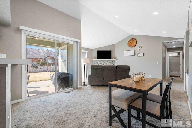 dining room featuring lofted ceiling, carpet, and visible vents