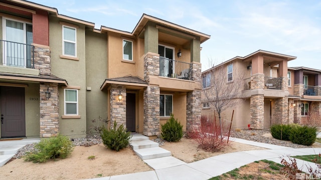 view of front of house featuring stone siding and stucco siding