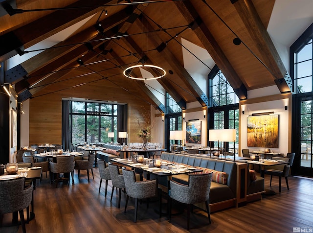 dining room featuring high vaulted ceiling, wood walls, wood finished floors, and beam ceiling