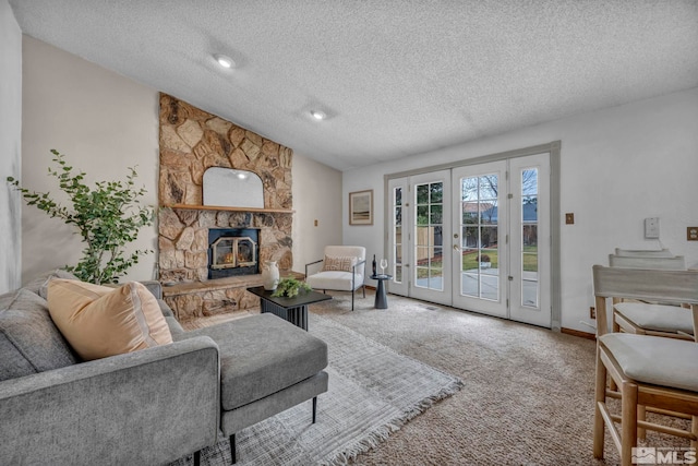 living area with a textured ceiling, french doors, carpet floors, a fireplace, and vaulted ceiling