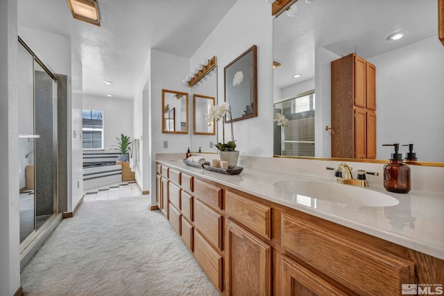 full bath featuring a sink, recessed lighting, a stall shower, and double vanity