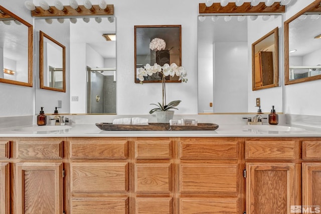 full bathroom featuring double vanity, a shower stall, and a sink